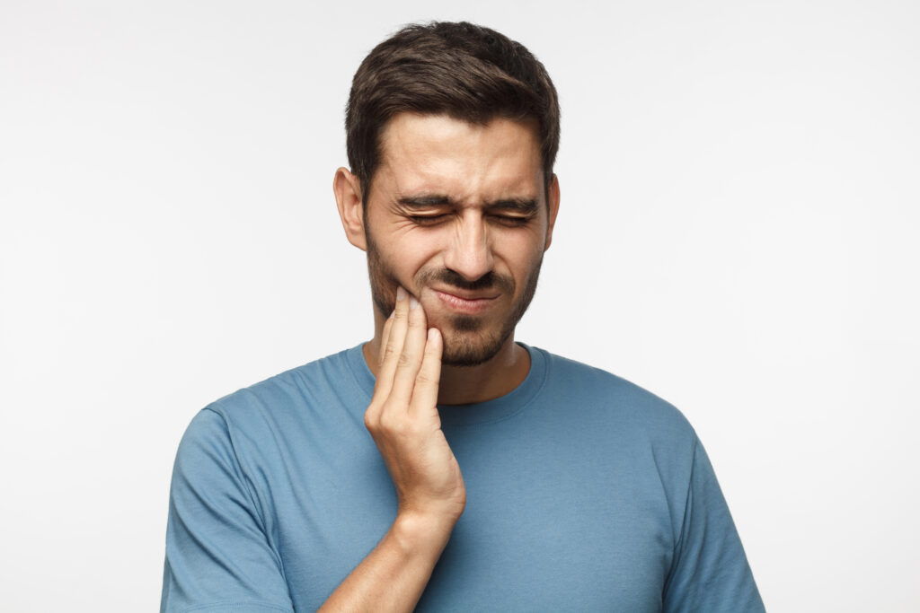 man holding mouth from tooth pain